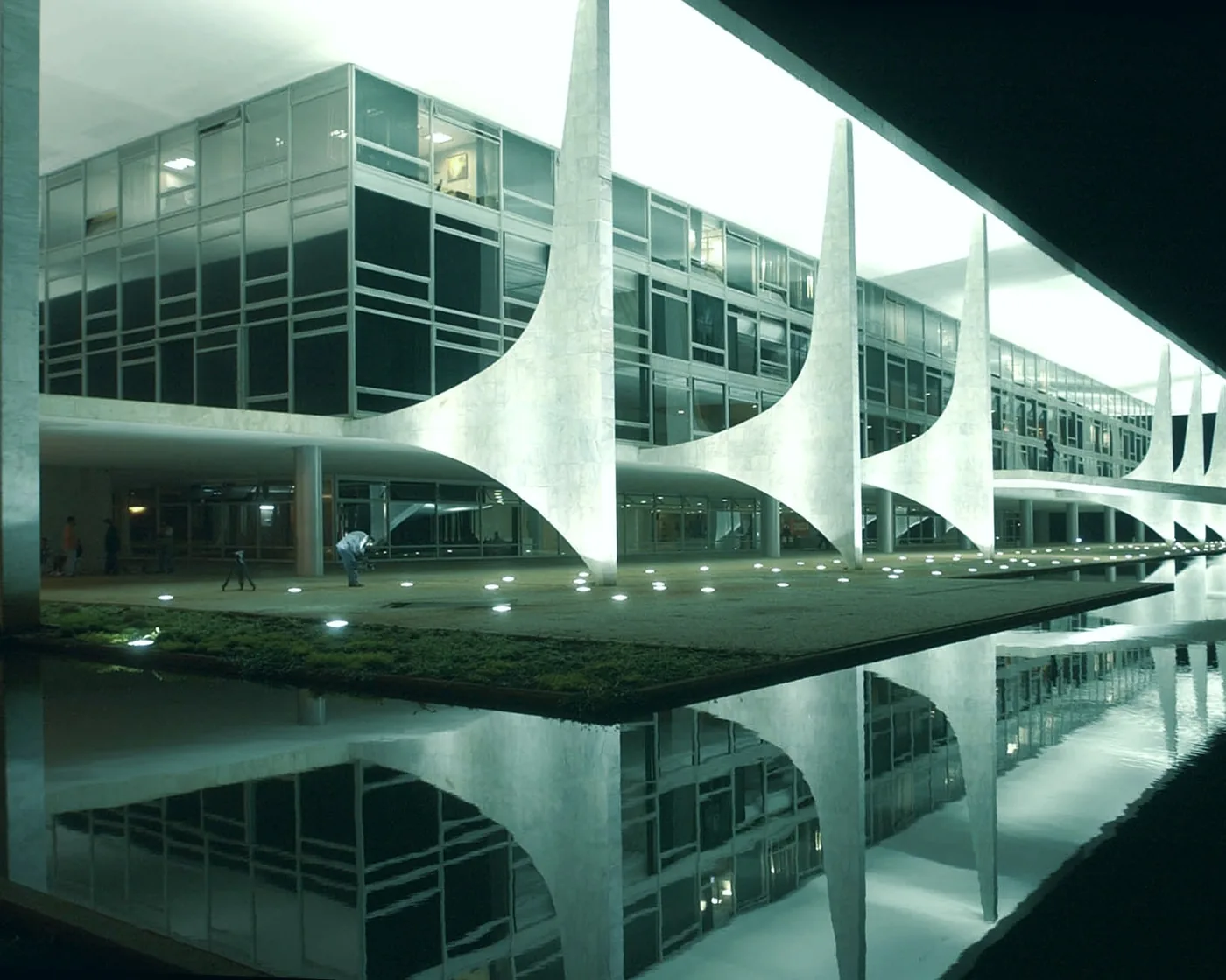 Palácio do Planalto, em Brasília, iluminado à noite, com suas colunas e o espelho d’água